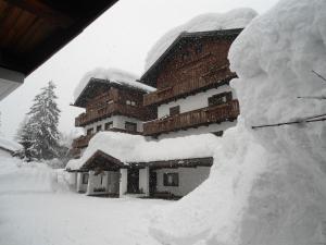 un edificio ricoperto di neve con un mucchio di neve di Hotel Principe a Cortina dʼAmpezzo