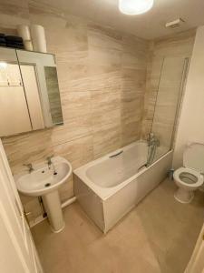 a bathroom with a tub and a sink and a toilet at Flat 18 in London