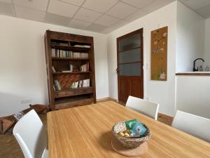 a dining room with a table and chairs and a book shelf at La Castanea, Charmante maison au pied du Granier in Chapareillan