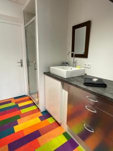 a bathroom with a sink and a colorful floor at La Castanea, Charmante maison au pied du Granier in Chapareillan