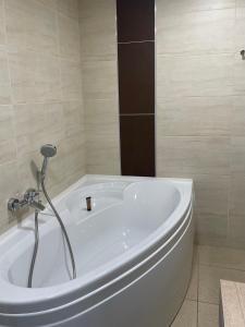 a white bath tub in a bathroom with a shower at Campanile Montpellier Ouest - Croix D'Argent in Montpellier