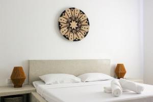 a clock on the wall above a bed at Paje White House Boutique Hotel in Paje