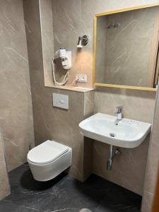 bagno con servizi igienici, lavandino e specchio di Hotel Principe ad Albacete