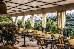 ein Restaurant mit Tischen und Stühlen und großen Fenstern in der Unterkunft Masseria La Chiusa Delle More in Peschici