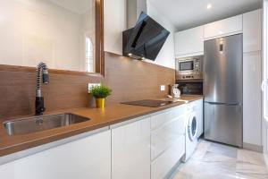uma cozinha com um lavatório e um frigorífico de aço inoxidável em Genteel Home Alfalfa em Sevilha
