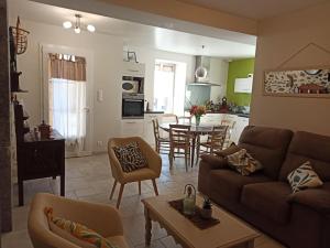 a living room and kitchen with a couch and a table at Gîte Pouquette in Aramits