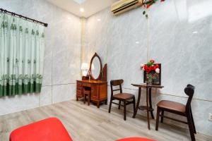 Thu Dau MotにあるKhách Sạn Tràng Anのテーブル、椅子、鏡が備わる客室です。