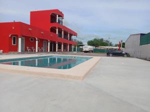 聖卡洛斯的住宿－Hacienda Gallardos 104-3，一座红色建筑前的游泳池