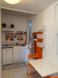 eine Küche mit einem Tisch, einem Tisch und einem Waschbecken in der Unterkunft Studio en duplex indépendant in Brignoles
