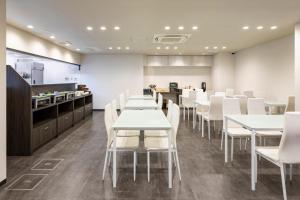 a dining room with white tables and white chairs at Hotel Axiainn Osaka-Uehonmachi in Osaka