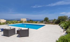 a swimming pool with two lounge chairs next to at Villa Lefki in Vamos