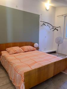 1 dormitorio con 1 cama con edredón naranja y blanco en Studio en duplex indépendant, en Brignoles