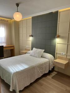 a bedroom with a white bed and a television at Hotel Principe in Albacete