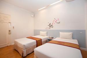 2 Betten in einem Zimmer mit weißen Wänden in der Unterkunft China Town Hotel - SHA Plus Certified in Bangkok