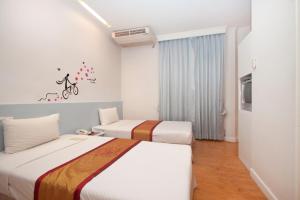 a hotel room with two beds and a tv at China Town Hotel - SHA Plus Certified in Bangkok