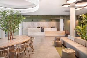 a lobby with tables and chairs and a waiting area at B&B Hotel Lisboa Aeroporto in Lisbon