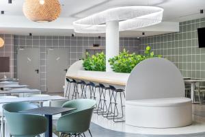 a restaurant with tables and chairs and a counter at B&B HOTEL Lisboa Aeroporto in Lisbon