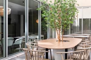 un tavolo con un albero in una stanza con sedie di B&B HOTEL Lisboa Aeroporto a Lisbona