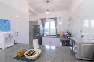 Il comprend une cuisine blanche équipée d'un réfrigérateur et d'un comptoir. dans l'établissement Cozy Crib, à Malindi