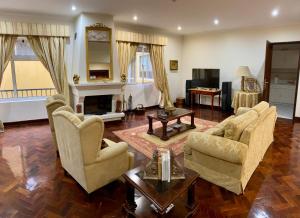 a living room with two chairs and a fireplace at DMCharme in Ponta Delgada