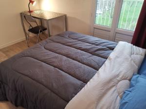 a bed in a room with a table and a table at apartment near the Breton coast 5 Location appartement près des côtes bretonnes in Saint-Brieuc