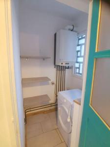 a small bathroom with a toilet and a refrigerator at apartment near the Breton coast 5 Location appartement près des côtes bretonnes in Saint-Brieuc