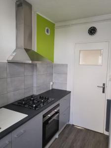 a kitchen with a stove top oven next to a door at apartment near the Breton coast 5 Location appartement près des côtes bretonnes in Saint-Brieuc