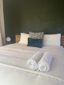 a white bed with two towels on it at Spacious 2-bed, 2-bath villa with garden and parking in Mataffin
