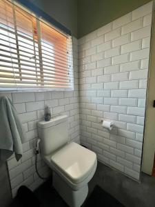 a white bathroom with a toilet and a window at Spacious 2-bed, 2-bath villa with garden and parking in Mataffin