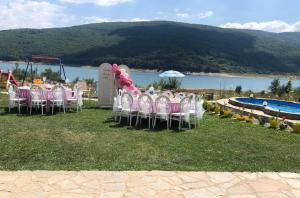 a group of tables and chairs in front of a pool at LUX Villa Mavrovo in Mavrovo