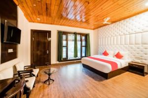 ein Schlafzimmer mit einem Bett und einem Schreibtisch in einem Zimmer in der Unterkunft Goroomgo Blue Moon Resort Lake View Mall Road Bhimtal - Best Seller in Nainital