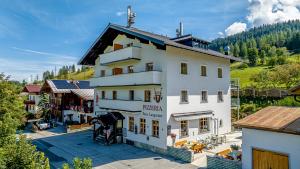 a large white building with a lot of windows at Ferienwohnungen Restaurant Pizzeria Langreiter in Embach