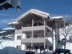 un grand bâtiment avec de la neige en haut dans l'établissement Chalet Birkenhof, à Saalbach-Hinterglemm