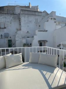 a bed on a balcony with pillows on it at BELLE HOME OSTUNI vasca vista mare in Ostuni +74 photos