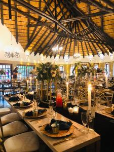 una sala da pranzo con un lungo tavolo con candele di Okahandja Country Hotel a Okahandja