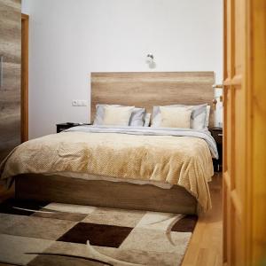 1 dormitorio con 1 cama grande y cabecero de madera en Klaudia Vendégház, en Mórahalom