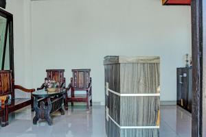 um quarto com uma mesa e cadeiras e um frigorífico em OYO 91720 Hotel Yotowawa em Kupang