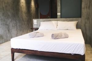 a bed with white sheets and two pillows on it at Pobla Hotel in Oslob