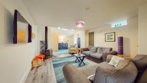 a living room with two couches and a fireplace at Peibio at Llanfair Hall in Dwyran