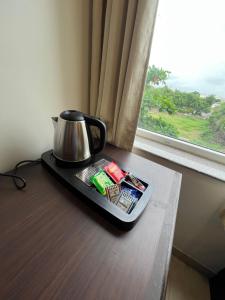 un hervidor de agua en una bandeja en una mesa junto a una ventana en Sheerha Royal Residency, en Jaipur