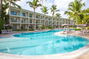 a pool at the resort with chairs and palm trees at Impressive Premium Punta Cana - All Inclusive in Punta Cana