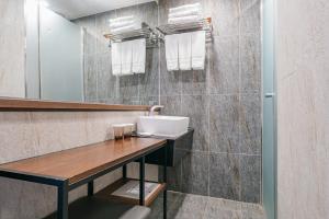 a bathroom with a sink and a mirror at Hotel With City in Jeju