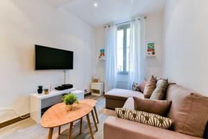 a living room with a couch and a tv at CMG - Bel appartement - 5 min à pied du Palais des Festivals in Cannes