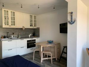 une cuisine avec des placards blancs et une table en bois dans l'établissement Appartement 4 étoiles Golfe de St Tropez, à Cogolin