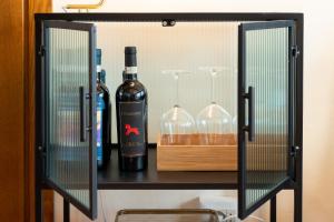 a shelf with two bottles of wine and glasses at SPIRIT OF FLORENCE Boutique Rooms in Florence