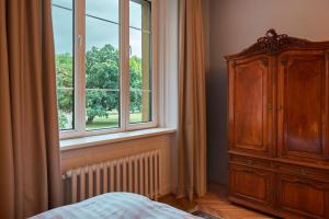 ブダペストにあるSchieszl Apartments 1の大きな窓と木製のキャビネット付きのベッドルーム1室が備わります。