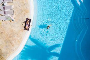 an overhead view of a man swimming in a pool next to a beach at Impressive Premium Punta Cana - All Inclusive in Punta Cana
