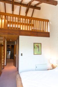 una camera con letto bianco e soffitti in legno di Le Freudeneck a Wangenbourg