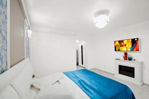 a white bedroom with a blue bed and a fireplace at Panorama Dunarii in Galaţi