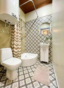 a bathroom with a toilet and a sink and a mirror at Daugavpils Delux in Rīga